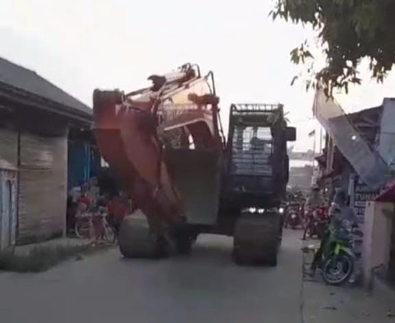 Warga Dua Desa Di Kecamatan Jayanti Di Hebohkan dengan adanya Alat berat (Beko) Melintas Di Jalan Pemukiman Warga
